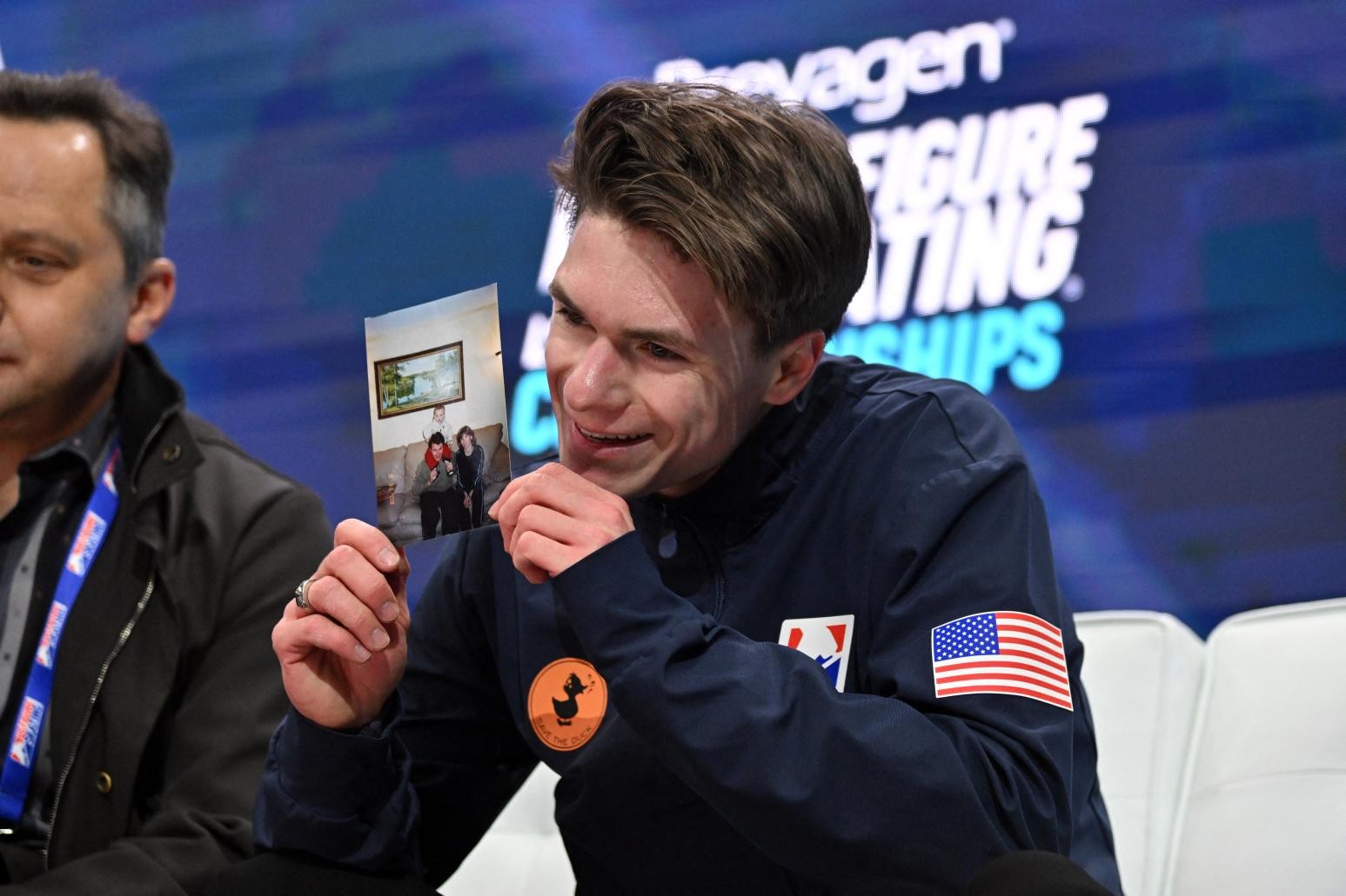 納烏莫夫手拿雙親照片，激動不已。（圖／路透社）