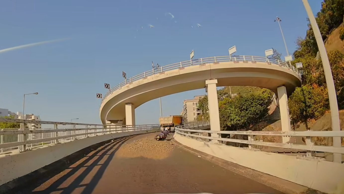 大埔道泥頭車泥石濺瀉鐵騎士倒地，網民笑稱為「Mario賽車」。(車cam L（香港群組）截圖)