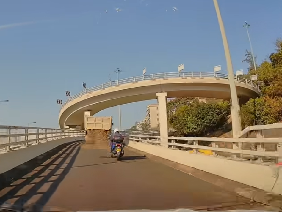 泥頭車車斗內的泥石突然濺瀉一地。(車cam L(香港群組)截圖)