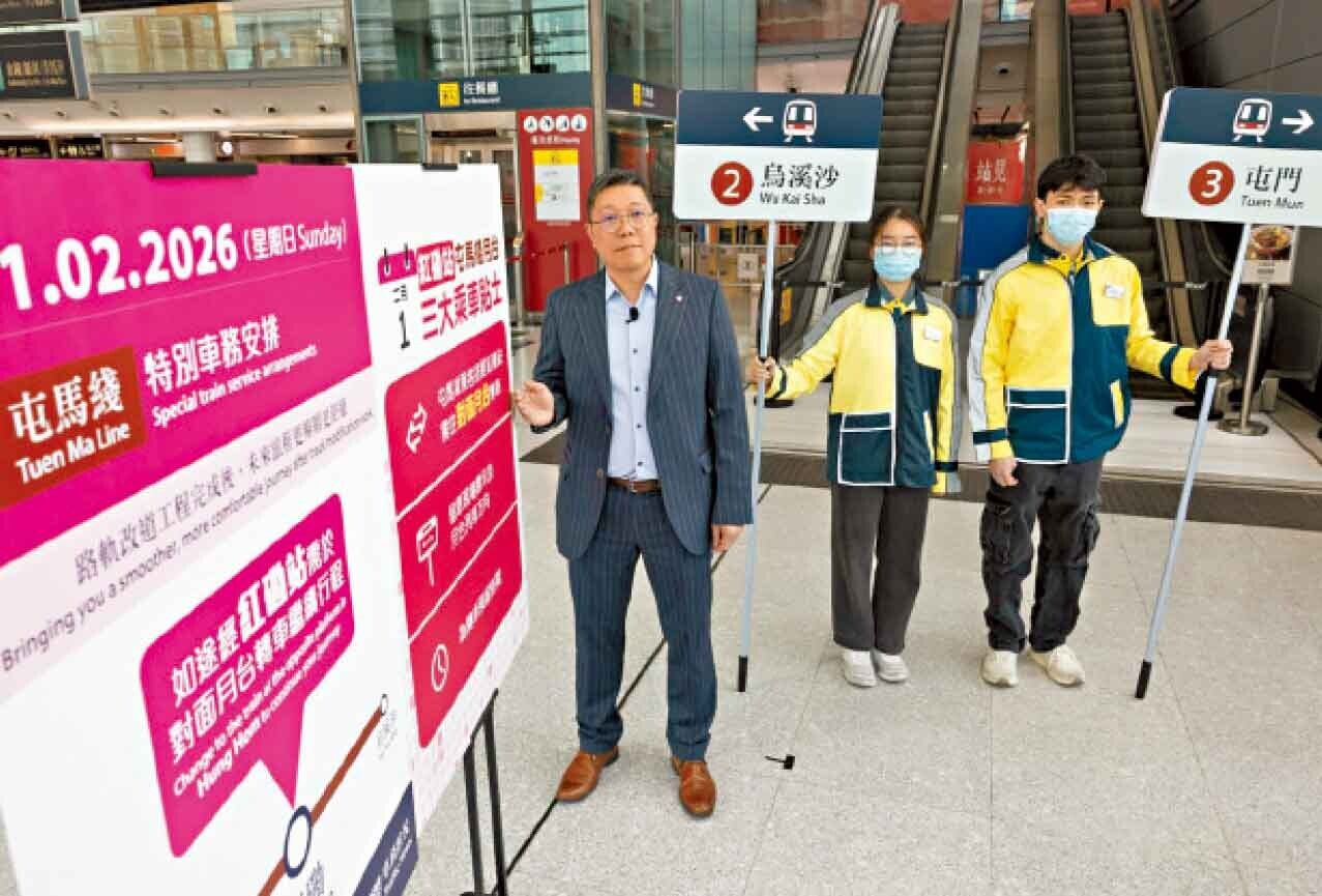 港鐵將派員舉起指示牌，協助乘客轉車。(蘇文傑攝)