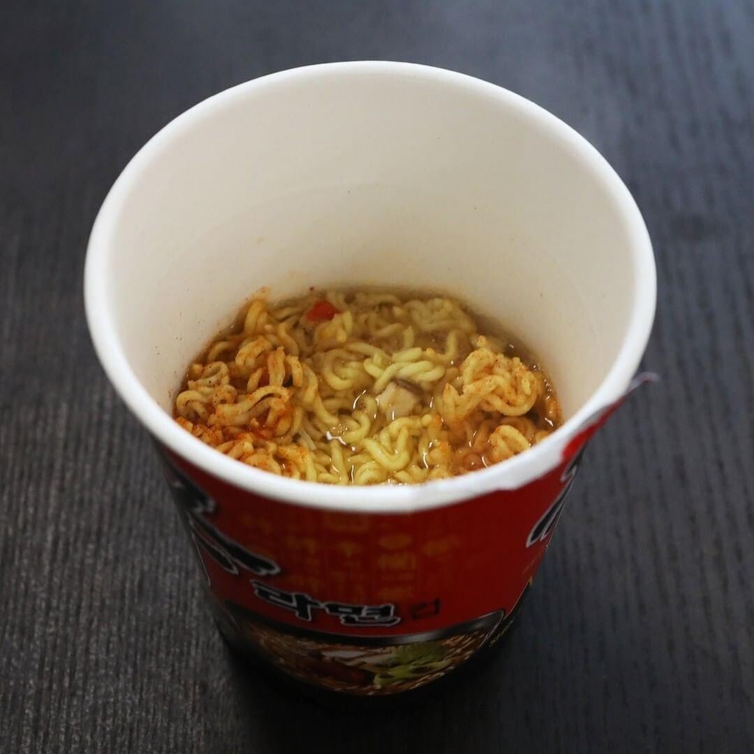 將杯麵醉捏碎後倒回杯中,加入熱水泡好。