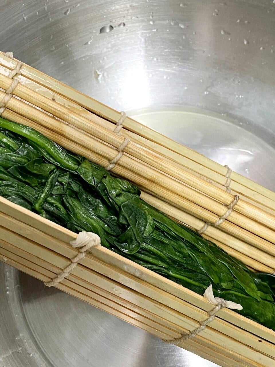 涼拌食譜│韓式涼拌菠菜 原棵菠菜順好同一方向直排在壽司蓆上,大力捲實,擠乾水,再切兩吋長的小段。芝麻用刀背略搗碎。