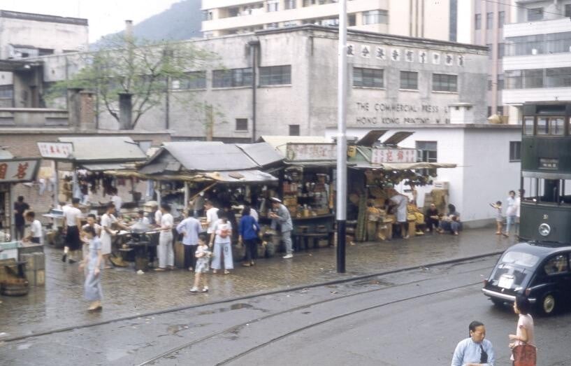 圖片攝於1950年代北角,前方有電車及路軌,後方為商務印書館廠房。(圖片來源:香港舊照片Facebook專頁)