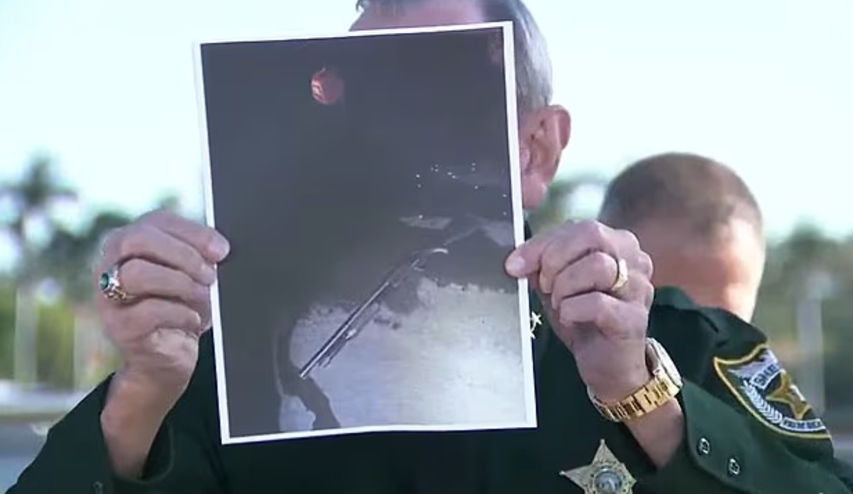 探員展示照片指男子被擊斃，遺下霰彈槍。(互聯網)