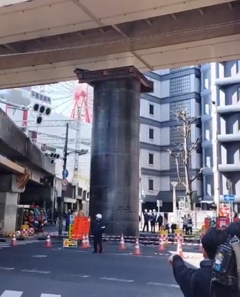 日本JR大阪站附近馬路一條深埋地下長約30米、直徑約5米的大型水管突「破土而出」無故隆起18米。(影片截圖/X)