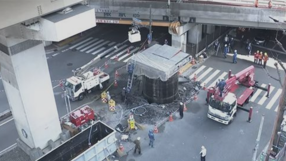 日本JR大阪站附近馬路一條深埋地下長約30米、直徑約5米的大型水管突「破土而出」無故隆起18米。(網上圖片)