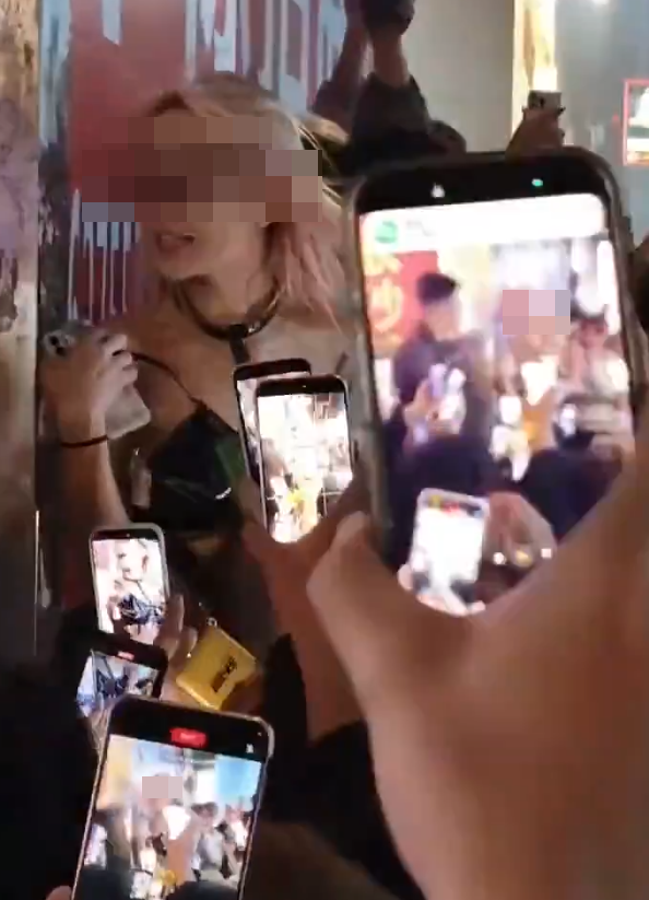 社交平台流傳長沙市一名衣着暴露的女子在解放西路當眾替一名男子口交,惹來逾百民眾圍觀拍攝,及後多名公安迅速趕抵現場驅散。(網上圖片/影片截圖)
