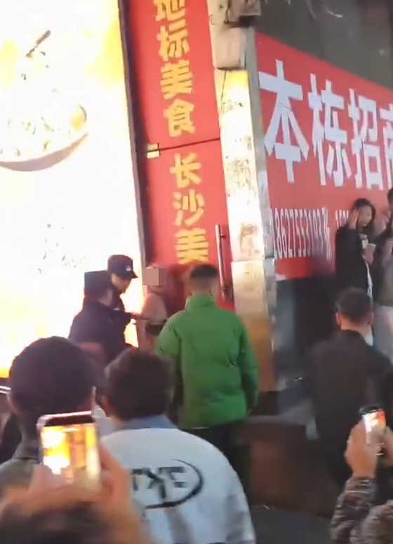 社交平台流傳長沙市一名衣着暴露的女子在解放西路當眾替一名男子口交,惹來逾百民眾圍觀拍攝,及後多名公安迅速趕抵現場驅散。(網上圖片/影片截圖)