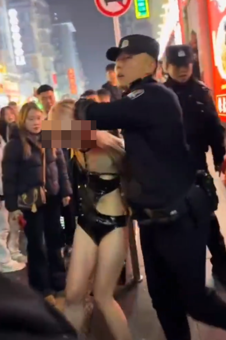社交平台流傳長沙市一名衣着暴露的女子在解放西路當眾替一名男子口交,惹來逾百民眾圍觀拍攝,及後多名公安迅速趕抵現場驅散。(網上圖片/影片截圖)