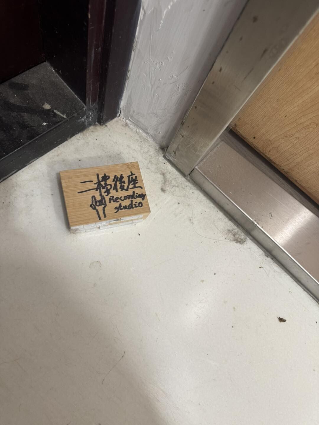 一名身穿雨褸赤腳男到「二樓後座」門前拆去門牌,掛上山寨門牌(圖)。(Facebook:Re:spect Music Magazine 紙談音樂影片截圖)
