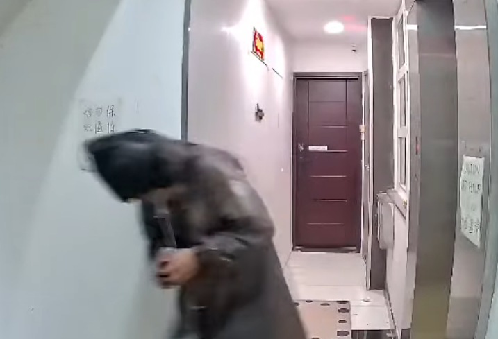 一名身穿雨褸赤腳男到「二樓後座」門前拆去門牌,掛上山寨門牌。(Facebook:Re:spect Music Magazine 紙談音樂影片截圖)