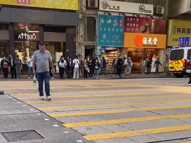旺角彌敦道一名男子「衝紅燈」過馬路,更「瀟灑」慢行,被駐守在旁的交通督導員截停。(Threads)