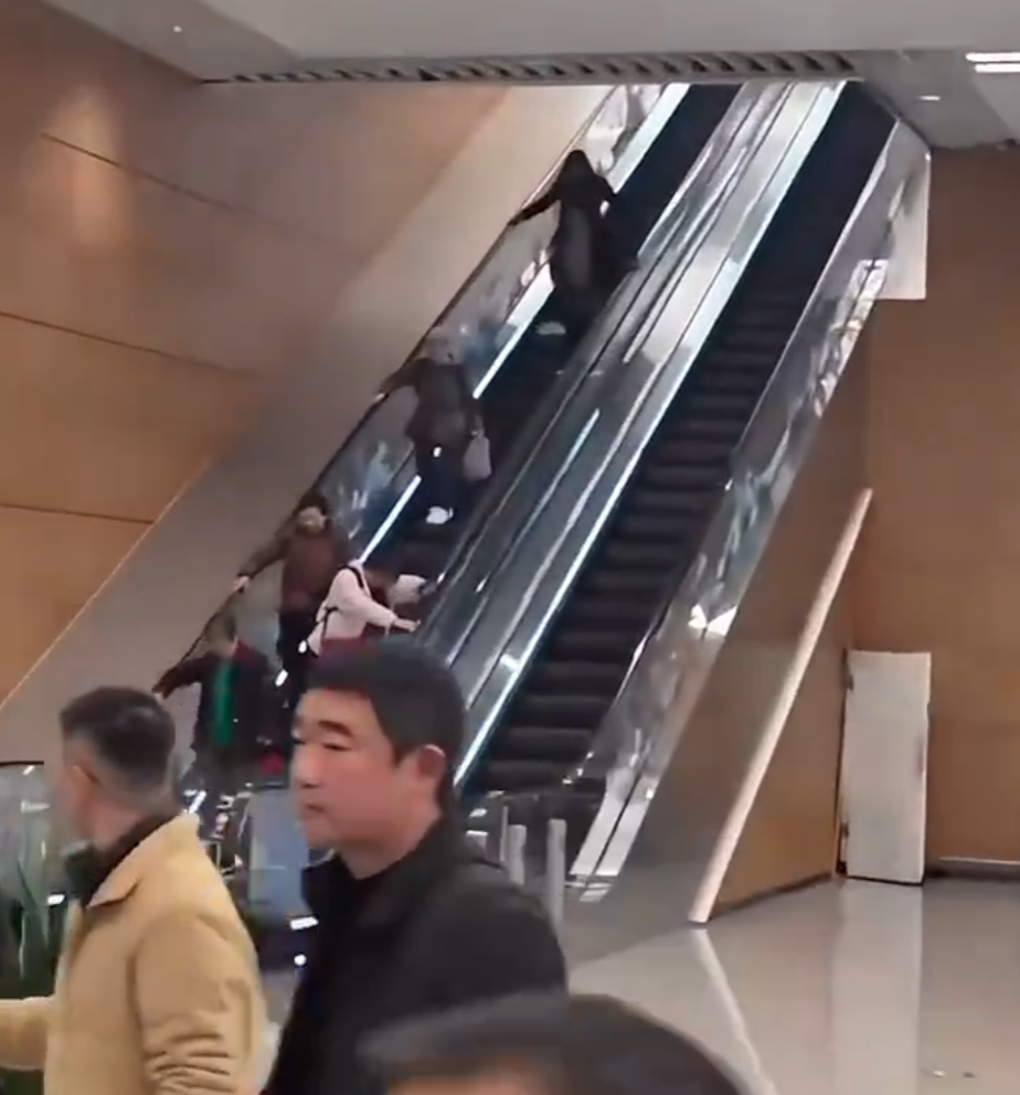 四川成都天府國際機場多名長者從上行扶手梯拿着行李往下走,場面驚險走,其他旅客發現後上前提醒勸止。(微博影片)