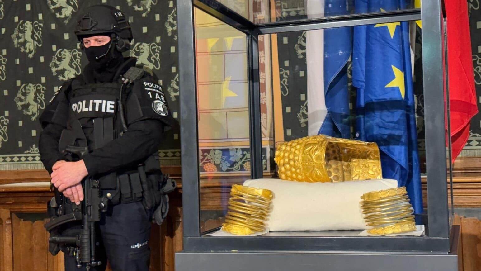 荷蘭宣布尋回被盜的羅馬尼亞黃金頭盔和2隻黃金臂環，記者會上有荷槍實彈的警察看守。（圖／美聯社）