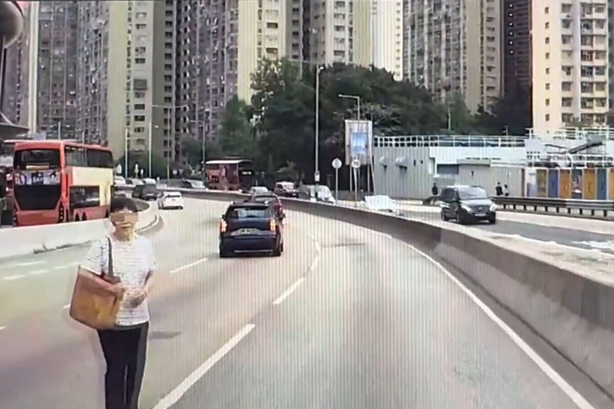 一名中年婦人無視危險,逕自在地面橫越龍翔道3條行車線。(Threads用戶stevenchanhk影片截圖)
