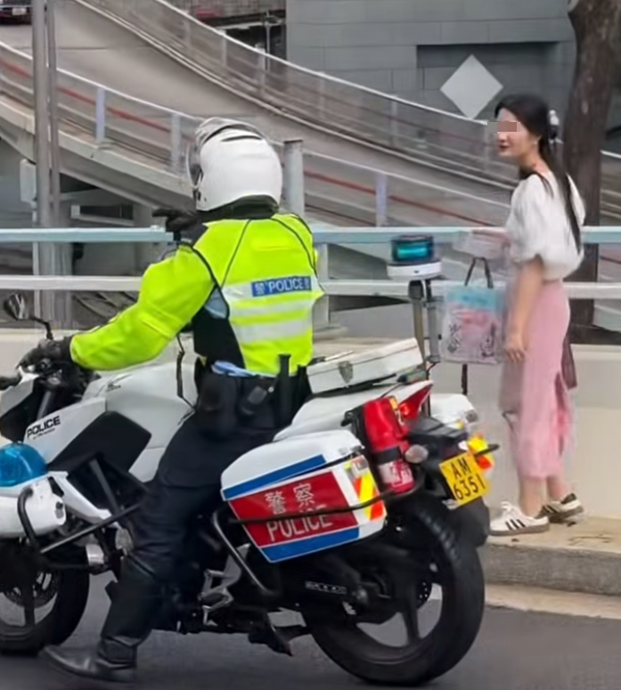 中環花園道天橋有女子疑誤入沒有行人路的天橋路壆位,正當她前往金鐘方向之際,有騎電單車的交通警駛至「護航」(車cam L(香港群組)FB)