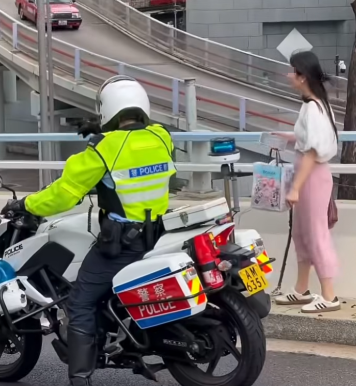 中環花園道天橋有女子疑誤入沒有行人路的天橋路壆位,正當她前往金鐘方向之際,有騎電單車的交通警駛至「護航」(車cam L(香港群組)FB)