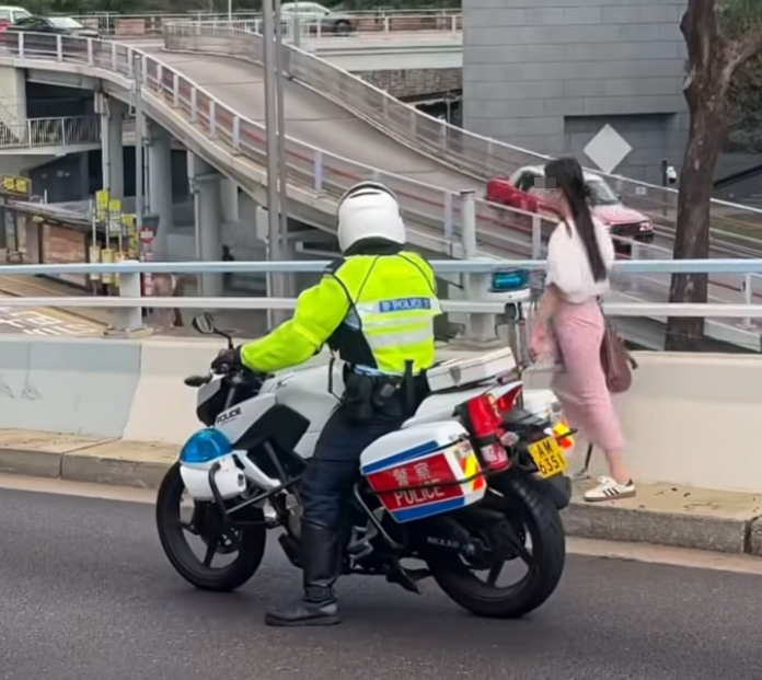中環花園道天橋有女子疑誤入沒有行人路的天橋路壆位,正當她前往金鐘方向之際,有騎電單車的交通警駛至「護航」(車cam L(香港群組)FB)