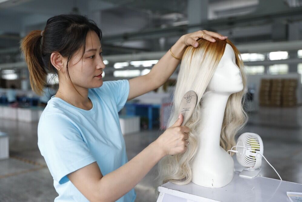 假髮製作過程複雜,除了脫鱗、染色就有多道工序,在成型過程中要經開料、整毛、磅髮、排髮、戴髮、插髮與壓三坑、捲髮、烘髮等十多個環節。(圖片來源:視覺中國)