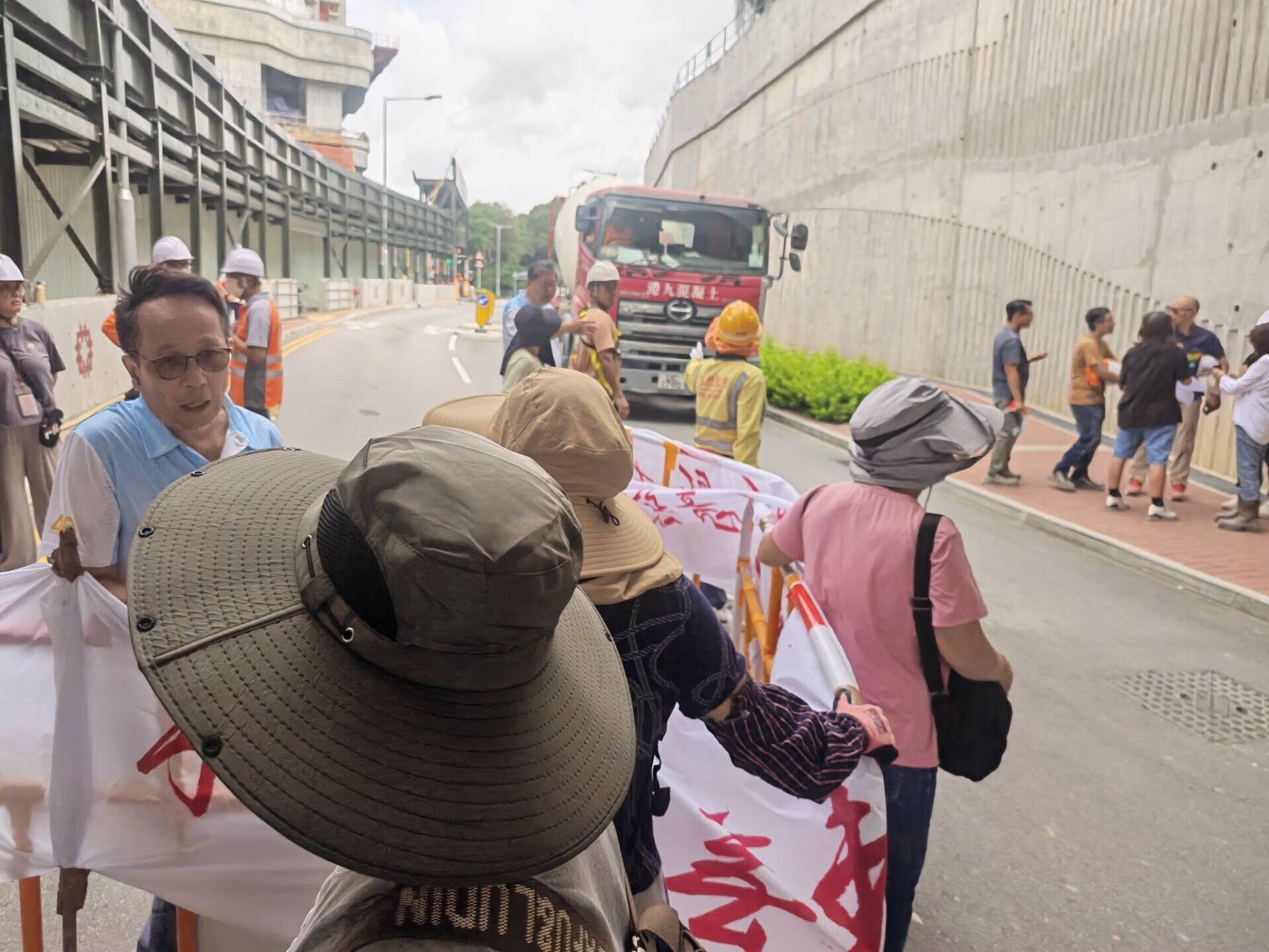 元朗橫洲一地盤逾30名工人拉起橫額,報稱被拖欠薪金,一度堵路阻擋混凝土車進入地盤(香港建造業總工會)