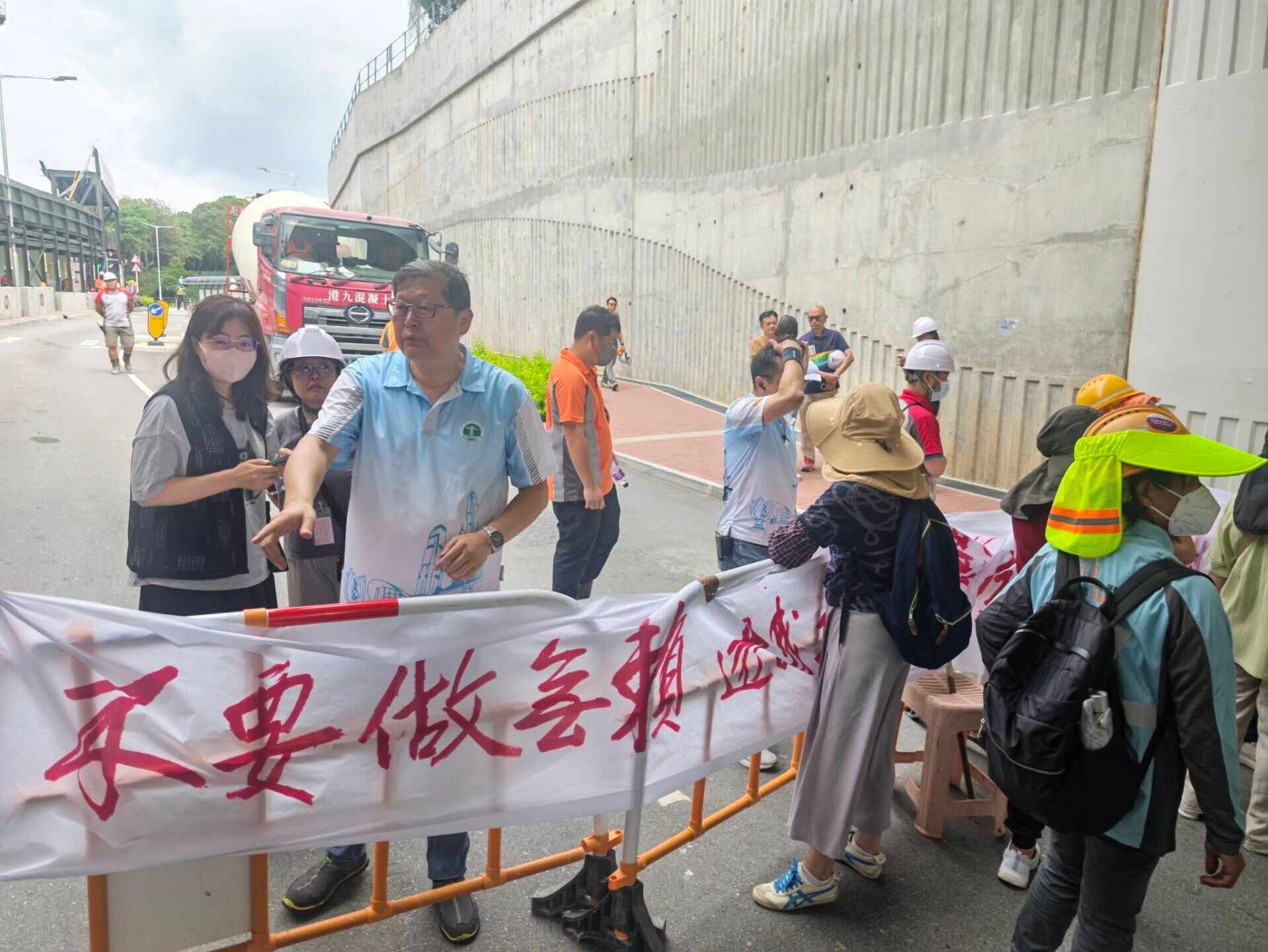 元朗橫洲一地盤逾30名工人拉起橫額,報稱被拖欠薪金,一度堵路阻擋混凝土車進入地盤(香港建造業總工會)