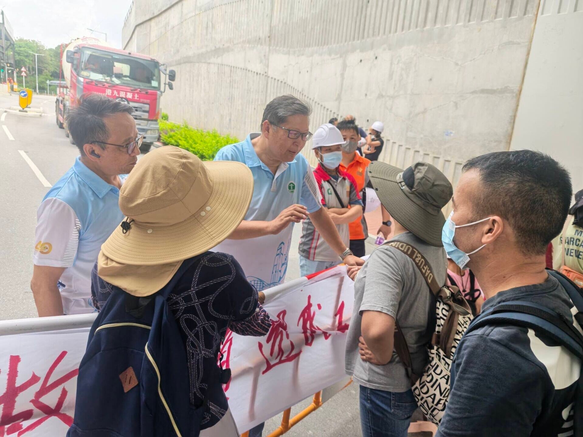 元朗橫洲一地盤逾30名工人拉起橫額,報稱被拖欠薪金,一度堵路阻擋混凝土車進入地盤(香港建造業總工會)
