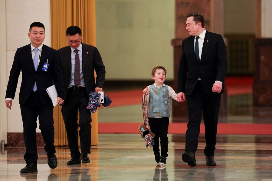 國務院總理李強晤美企CEO代表團,馬斯克帶同6歲兒子X Æ A-Xii到人民大會堂出席。X一臉雀躍。(美聯社)
