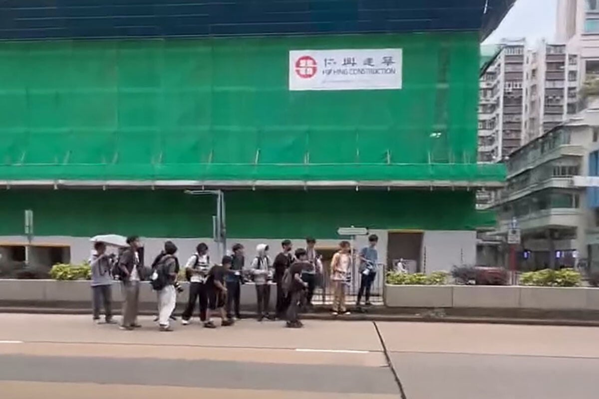 事發時有一群巴士迷站在路中心花槽,相信已拍攝完畢準備離開,未料其中一人捱撞。(網上影片截圖)