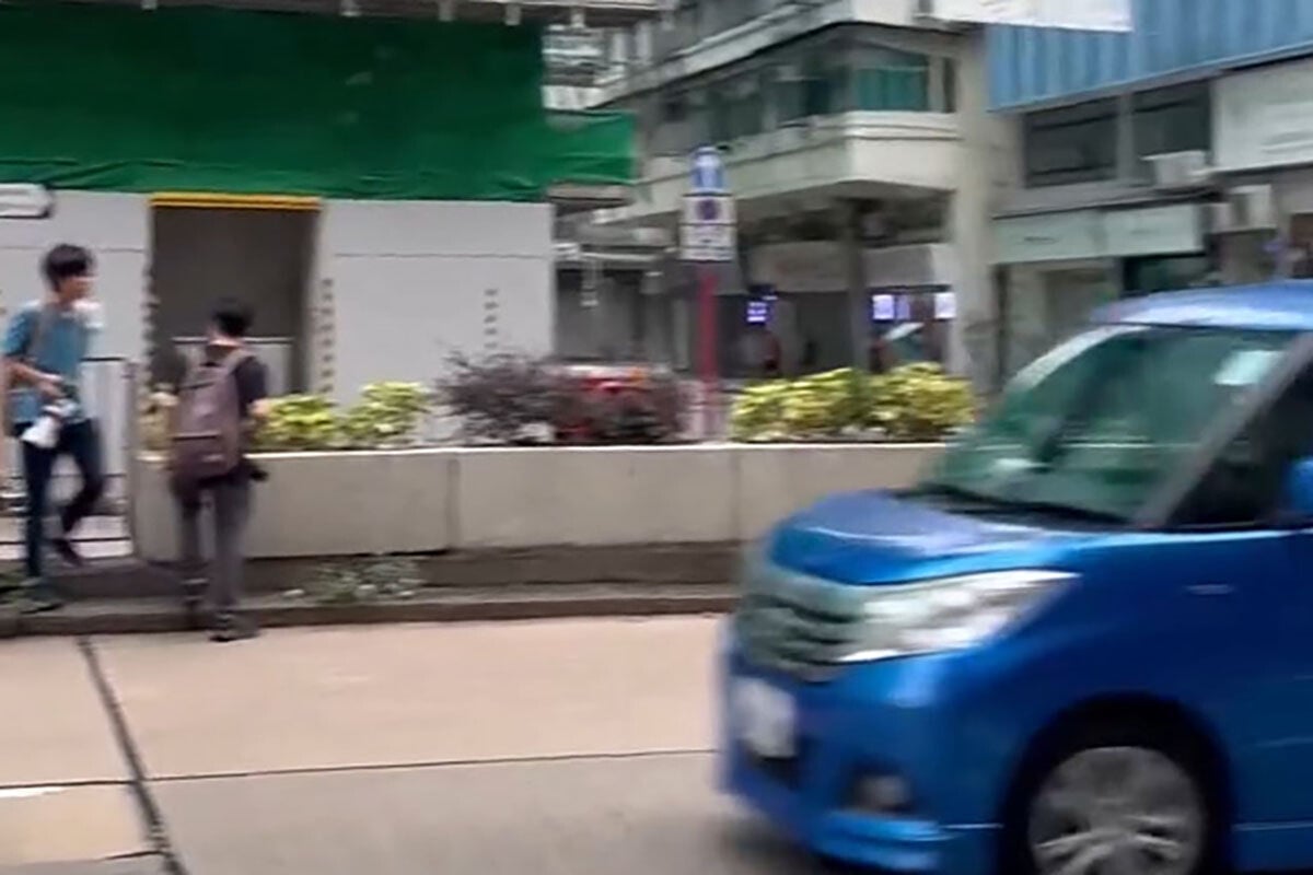 事發時有一群巴士迷站在路中心花槽,相信已拍攝完畢準備離開,未料其中一人捱撞。(網上影片截圖)