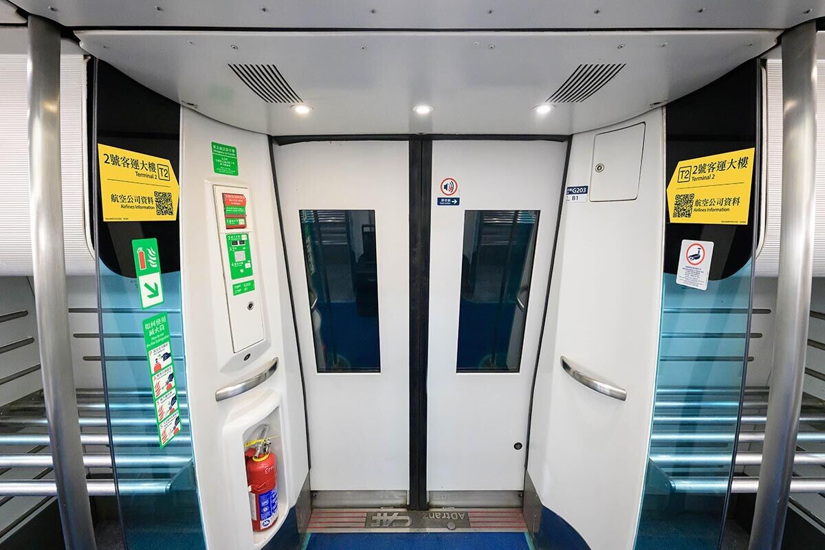 機場快綫列車車廂貼有一號及二號客運大樓的方向指示。(港鐵提供)
