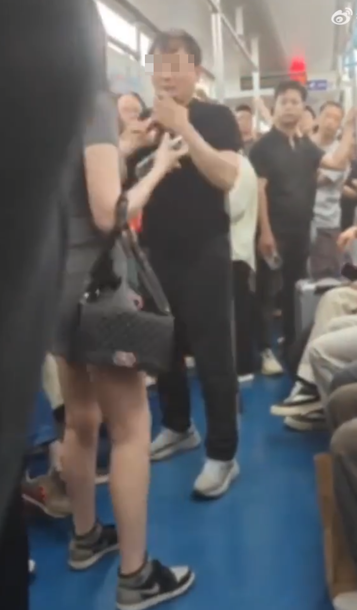 西安地鐵車廂內有女乘客聲稱遭一名年長男子偷拍,當場對質並要求對方刪除照片,惟對方未有配合,女乘客即當眾一巴掌掌摑,雙方一度糾纏。(影片截圖)