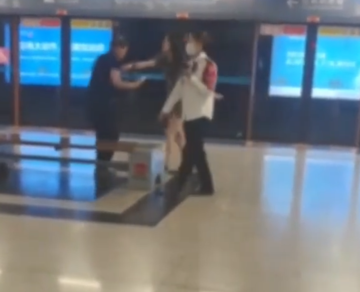 西安地鐵車廂內有女乘客聲稱遭一名年長男子偷拍,當場對質並要求對方刪除照片,惟對方未有配合,女乘客即當眾一巴掌掌摑,雙方一度糾纏。(影片截圖)
