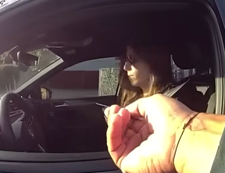 美國佛羅里達州一名女子開車時突然被警員截停,控她在駕駛時使用右手使用手機,惟女司機早因截肢失去右臂。(影片截圖)