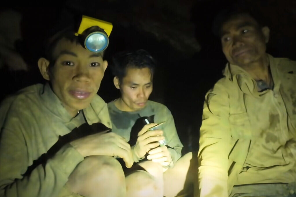 老撾洞穴救援任務發現5名生還者,救援隊運送飲品到洞內。(美聯社)