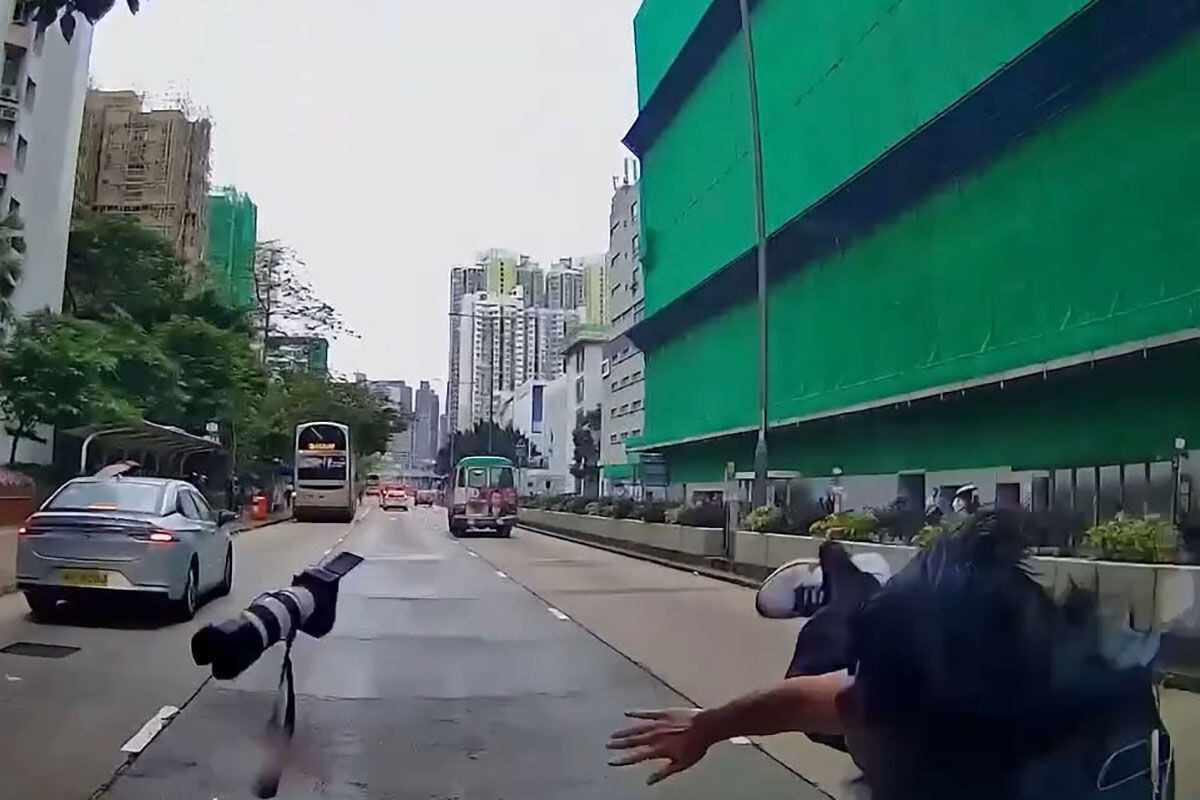 有車Cam片段顯示,一名巴士迷突從人群步出並無留意交通情況,最終捱撞,手中單反相機亦飛墮。(網上影片截圖)