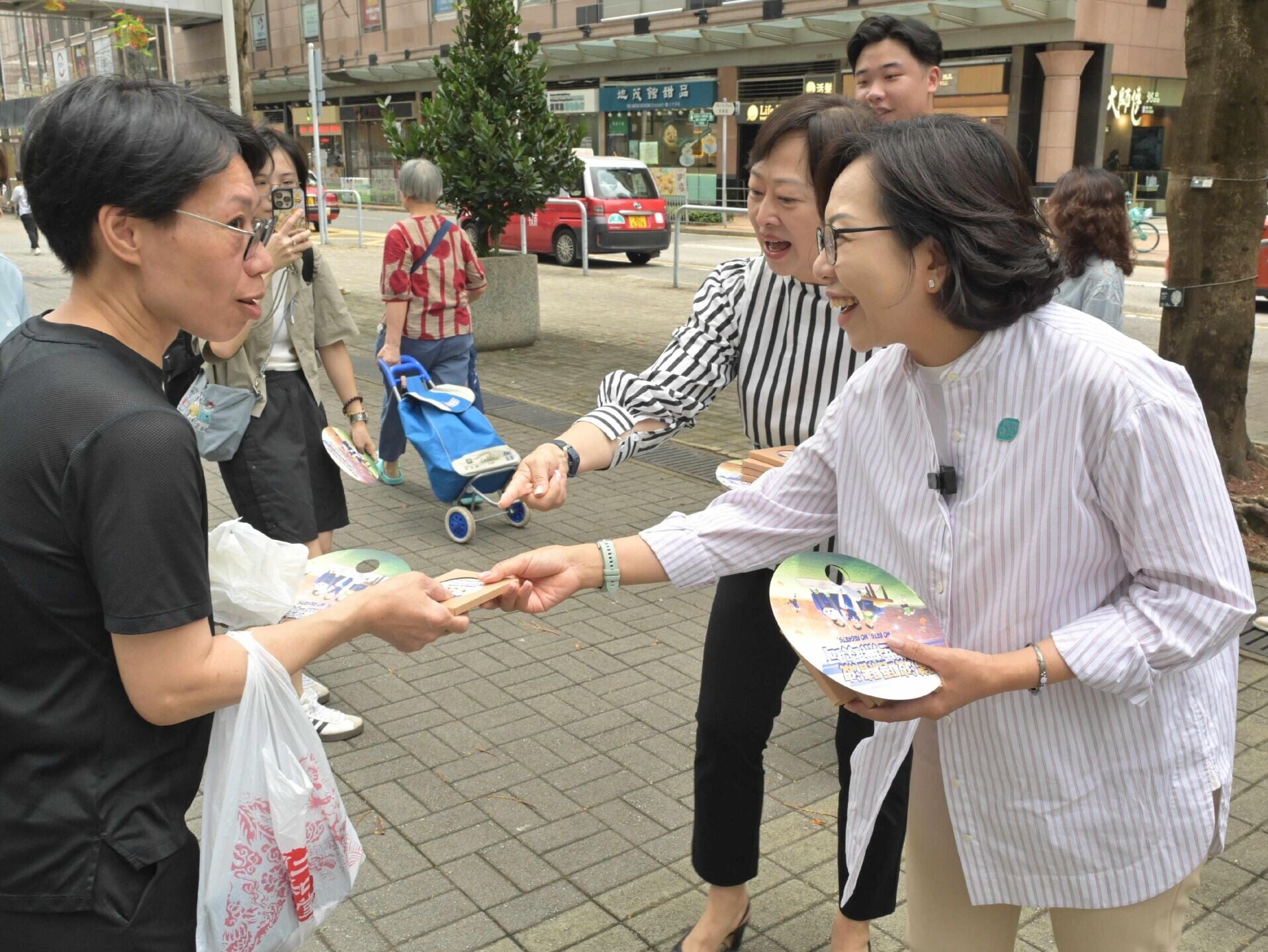 民政及青年事務局局長麥美娟(右一)及平和基金諮詢委員會主席陸海(右二)今日參觀流動宣傳車「抗賭平和號」,並向市民派發抗賭宣傳品。