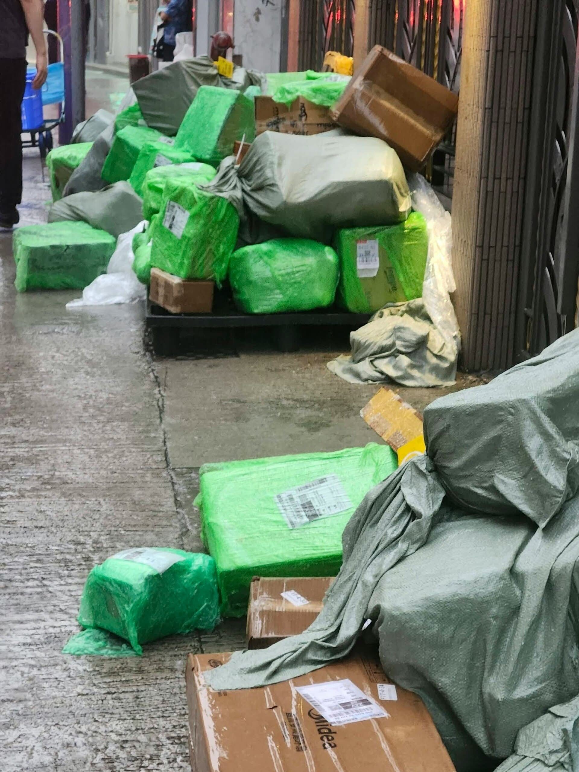 多區放在街頭的疑似拼多多網購包裹被「淋雨」,紙盒濕透,部份包裝更損毀。(網上圖片)