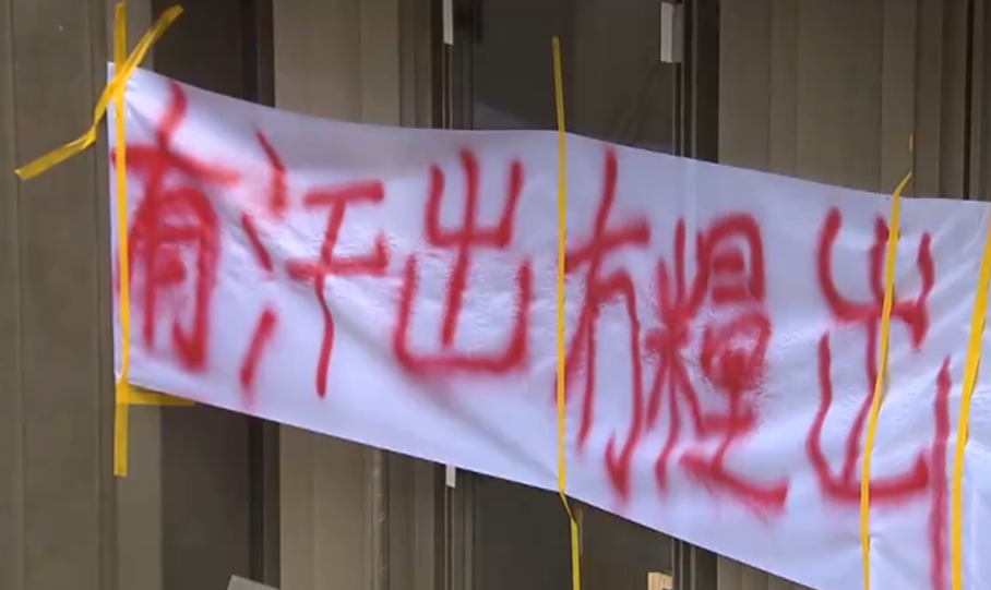 大約40名地盤工及清潔工冒雨聚集在贊善里1號一已經接近完工的樓盤建築地盤外,拉起「有汗出,冇糧出」橫額發起追薪行動(無線新聞畫面)
