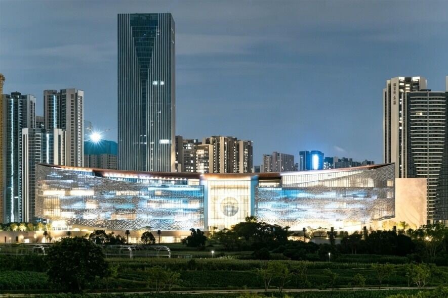 深圳國際美術館北館晚上亮燈後,通透的玻璃幕牆讓建築宛如一座發光的方舟,流線型的金屬構件在光影中更顯靈動,彷彿一幅流動的立體山水畫卷。(圖片來源:深圳光明微信)
