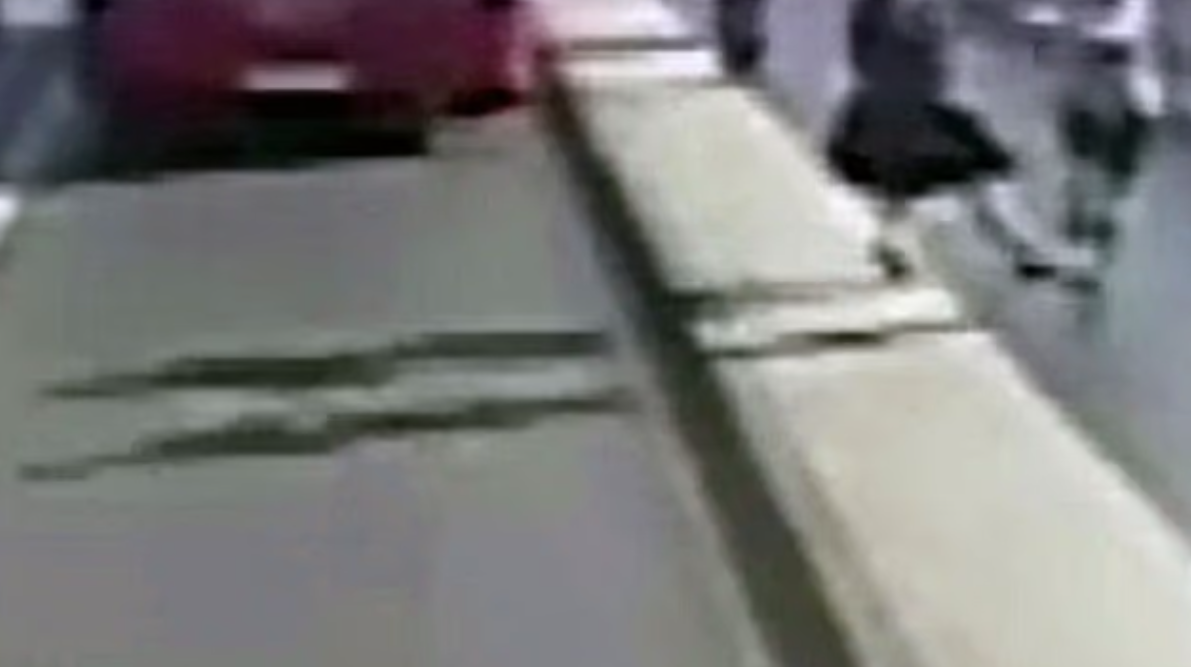 慢跑男把「擋路」的女事主推出馬路，身後正有雙層巴士駛至。(互聯網)
