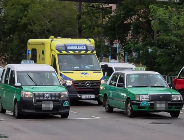 一輛救護車開啟閃燈鳴笛前往緊急救援現場,但在交通燈前被兩輛綠色的士阻擋,即使救護車持續鳴響警號,司機仍然堅持停在原位等候燈號,最終救護車只能無奈等待轉燈後才可繼續前行。(影片截圖)