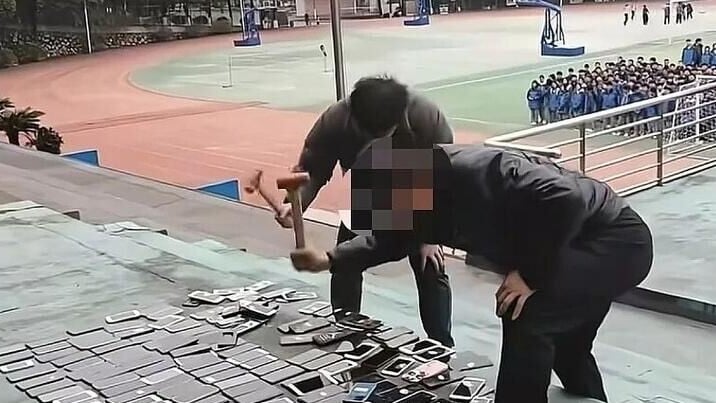 中國湖南一所學校，校方直接當眾用鐵鎚砸毀上百部手機。(縱覽新聞)