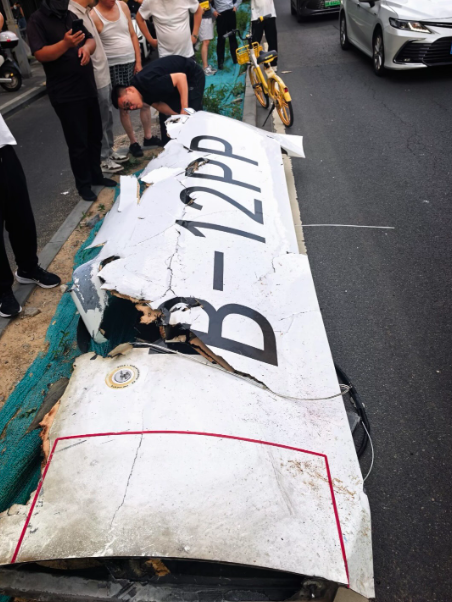 一架小型飛機撞上北京中信大廈後墜毀,大廈兩面玻璃破裂。該小型飛機則斷裂,部分殘骸掉落在大樓樓底和路面起火。(網上圖片/影片截圖)