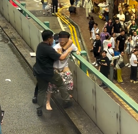 涉案男子落網一刻片段亦曝光,可見戴眼鏡的他在鵝頸橋街市、近羅素街對開堅拿道天橋上被制服,當時他與兩名警員糾纏,橋下大批市民圍觀,多名警員其後趕抵增援(影片截圖)