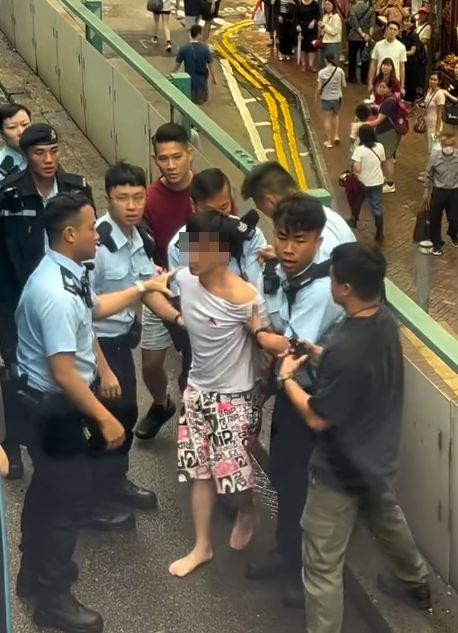 涉案男子落網一刻片段亦曝光,可見戴眼鏡的他在鵝頸橋街市、近羅素街對開堅拿道天橋上被制服,當時他與兩名警員糾纏,橋下大批市民圍觀,多名警員其後趕抵增援(影片截圖)
