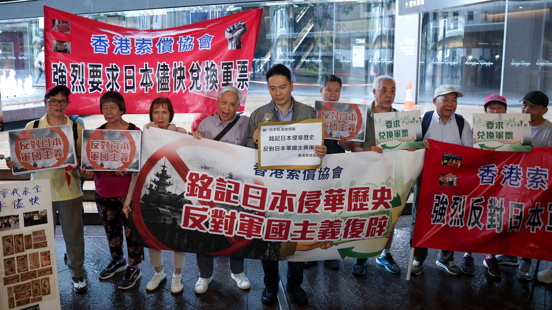 「七七盧溝橋事變」89周年，香港索償協會代表聯同民建聯立法會議員周浩鼎，到總領事館所在的中環交易廣場樓下抗議(中通社)