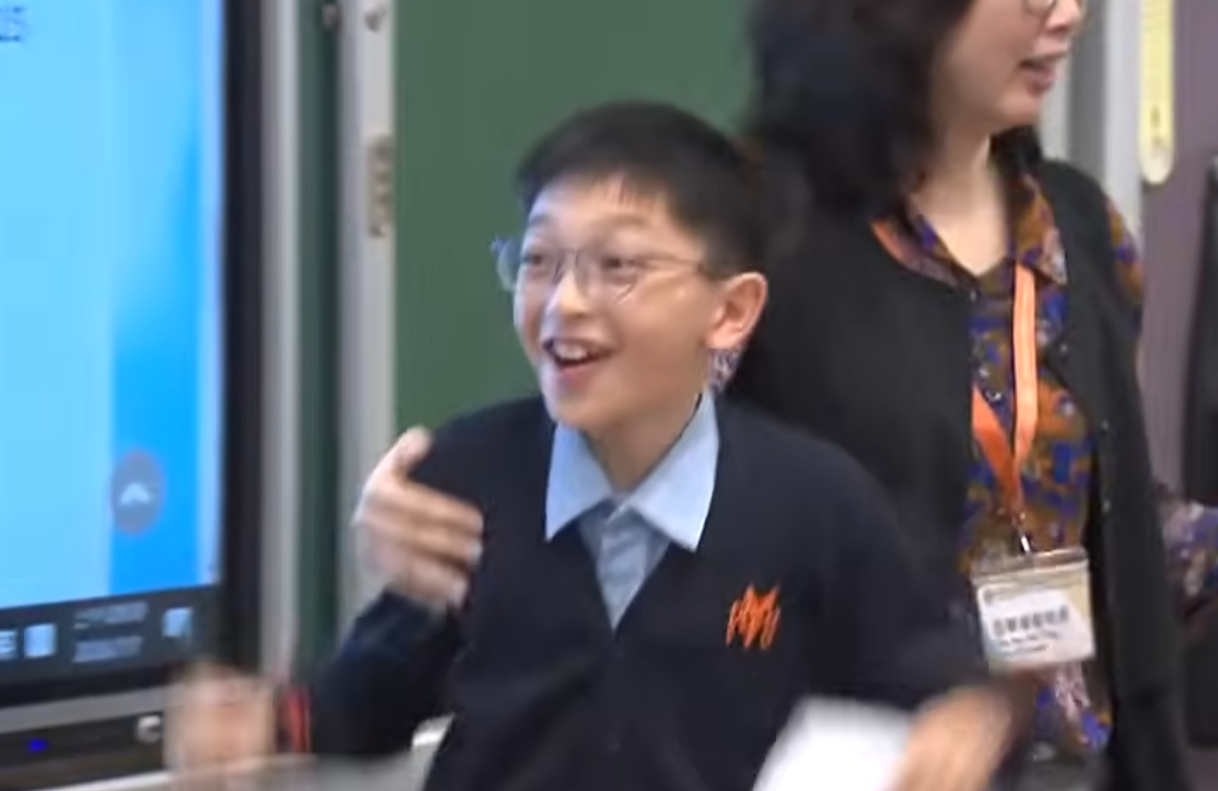 升中派位結果揭盅,油蔴地天主教小學(海泓道)一名男學生朱同學獲派心儀的九龍華仁中學,當場興奮尖叫開心到彈起,受訪時真情流露化身「Happy貓」,無綫新聞播出片段後,連女主播看畢亦「嘴角上揚」。(無綫新聞畫面)