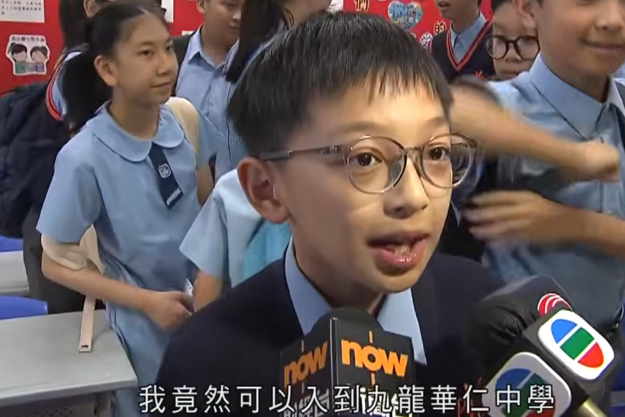升中派位結果揭盅,油蔴地天主教小學(海泓道)一名男學生朱同學獲派心儀的九龍華仁中學,當場興奮尖叫開心到彈起,受訪時真情流露化身「Happy貓」,無綫新聞播出片段後,連女主播看畢亦「嘴角上揚」。(無綫新聞畫面)