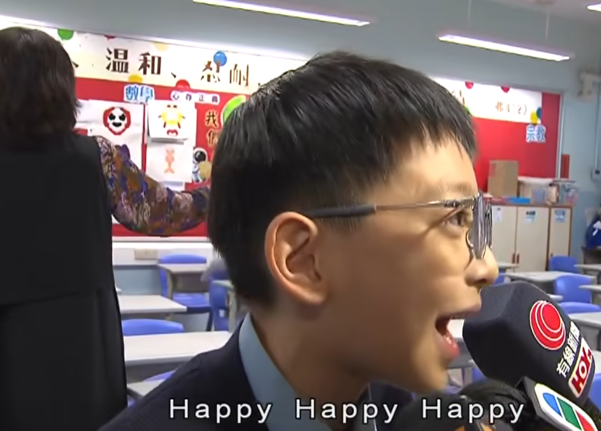 升中派位結果揭盅,油蔴地天主教小學(海泓道)一名男學生朱同學獲派心儀的九龍華仁中學,當場興奮尖叫開心到彈起,受訪時真情流露化身「Happy貓」,無綫新聞播出片段後,連女主播看畢亦「嘴角上揚」。(無綫新聞畫面)