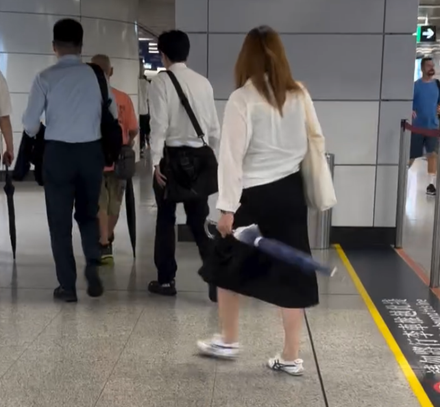 社交平台流傳影片,一名女子在港鐵中環站及香港站之間通道內站內橫向持傘走路,期間大幅度前後擺動如揮劍,幸當時站內人流不算密集,未有傷及他人。(Threads)